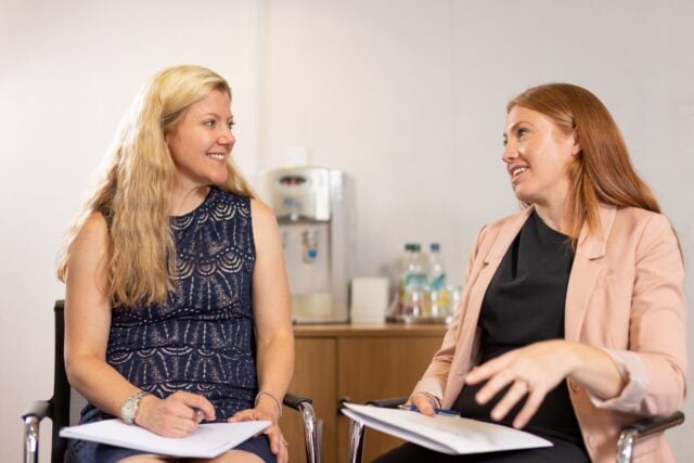 Jo W and Holly looking at each other and talking