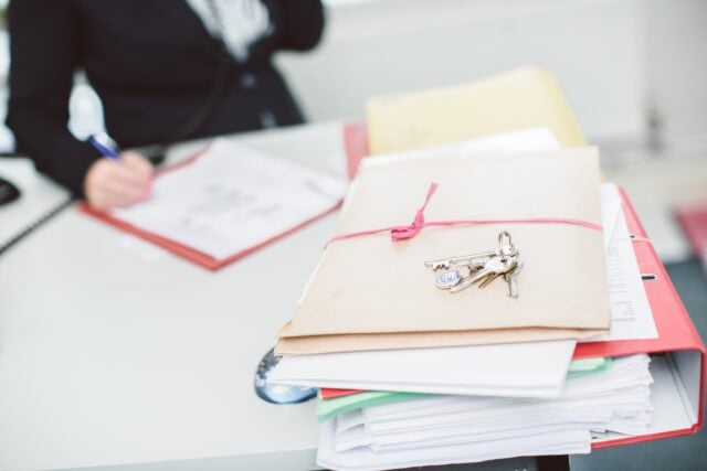 Files On Desk, Keys, Person On Phone