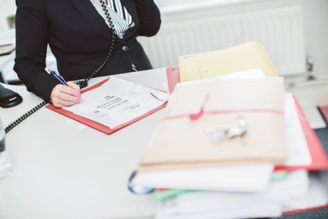 Files On Desk, Keys, Person On Phone