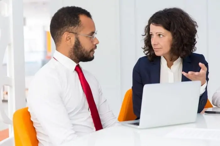 Settlement agreement consultation - solicitor explaining legal terms to client in modern office
