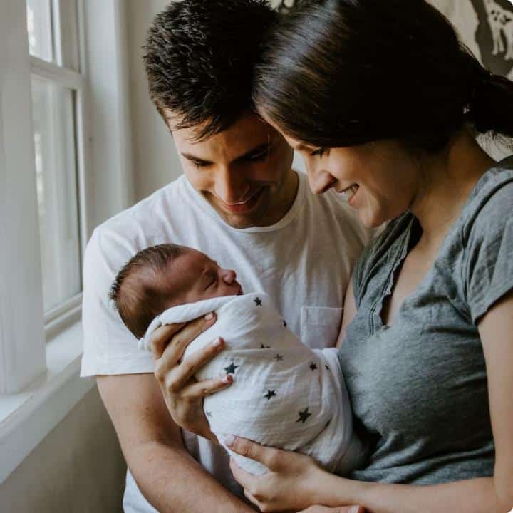 New parents holding their baby