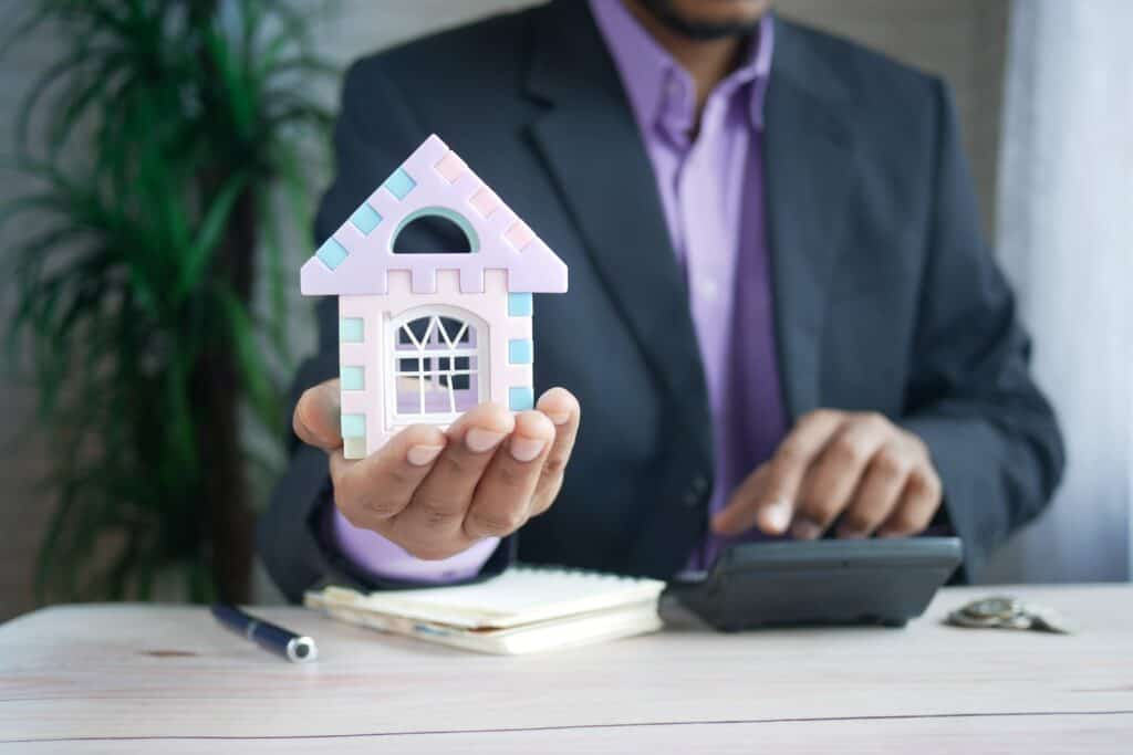 Man holding up a figure of a house