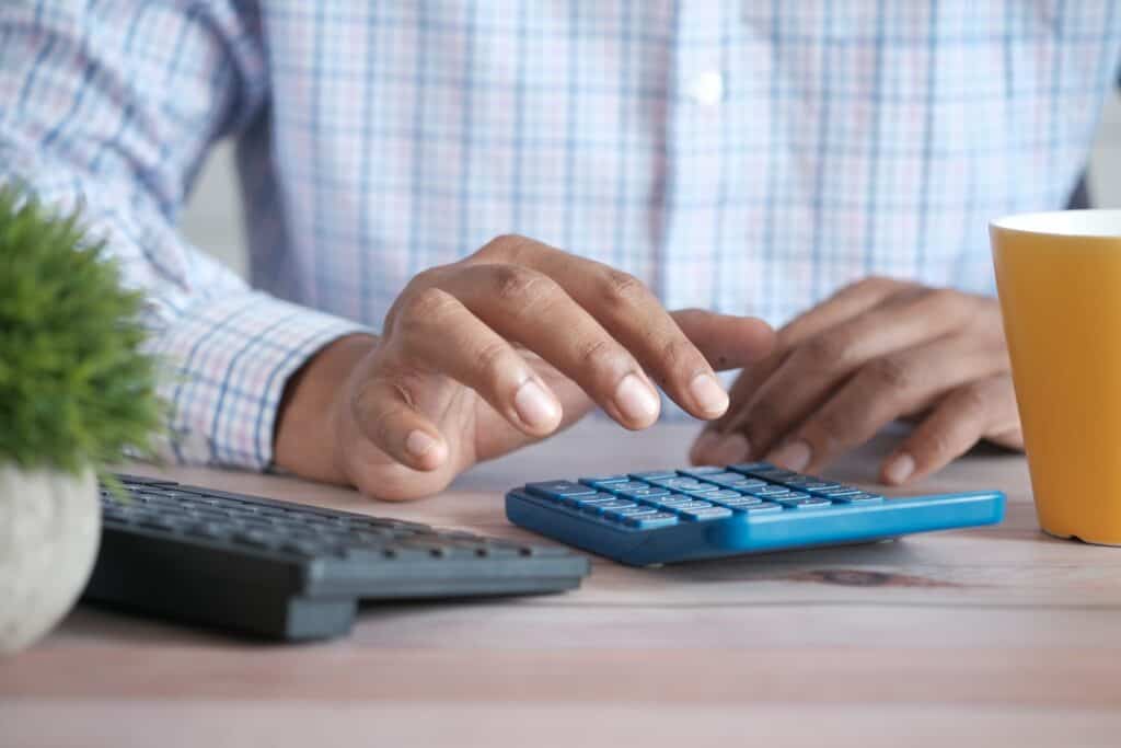 Man typing numbers into a calculator