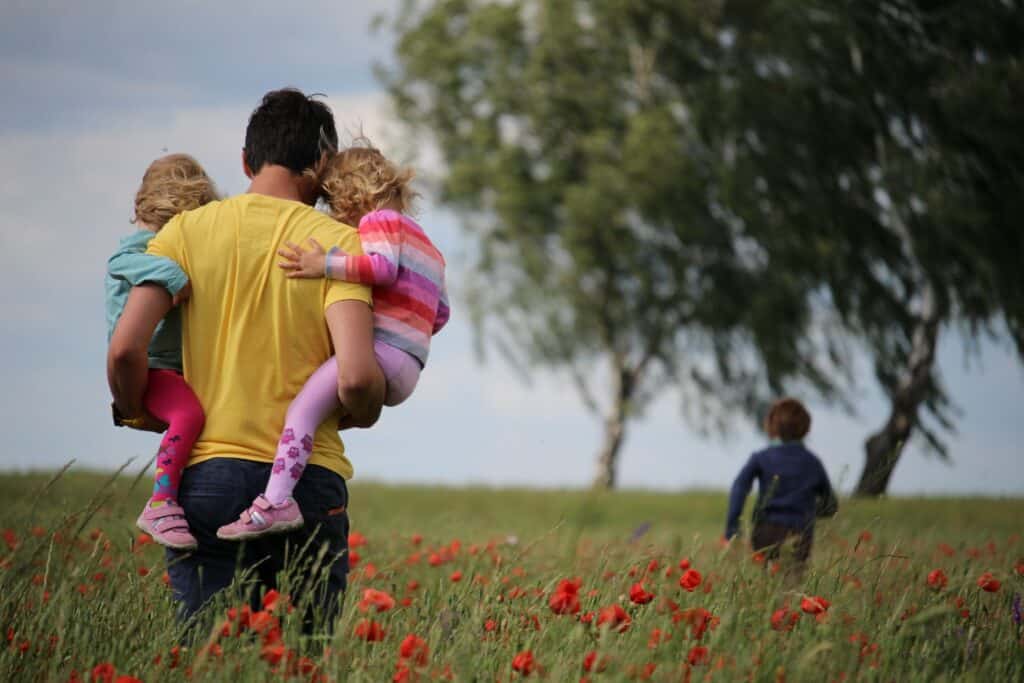 Family walking in a field on a summer evening