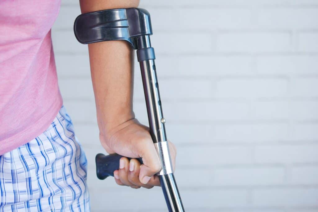 person supporting themselves with a crutch.